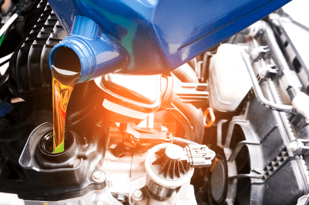 Oil Change - Mechanic adding new motor oil to motor