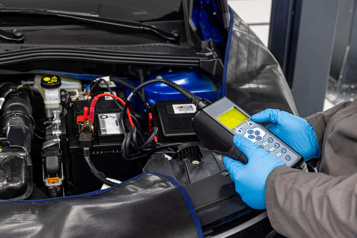 A technician uses a device to test the strength of a car battery.