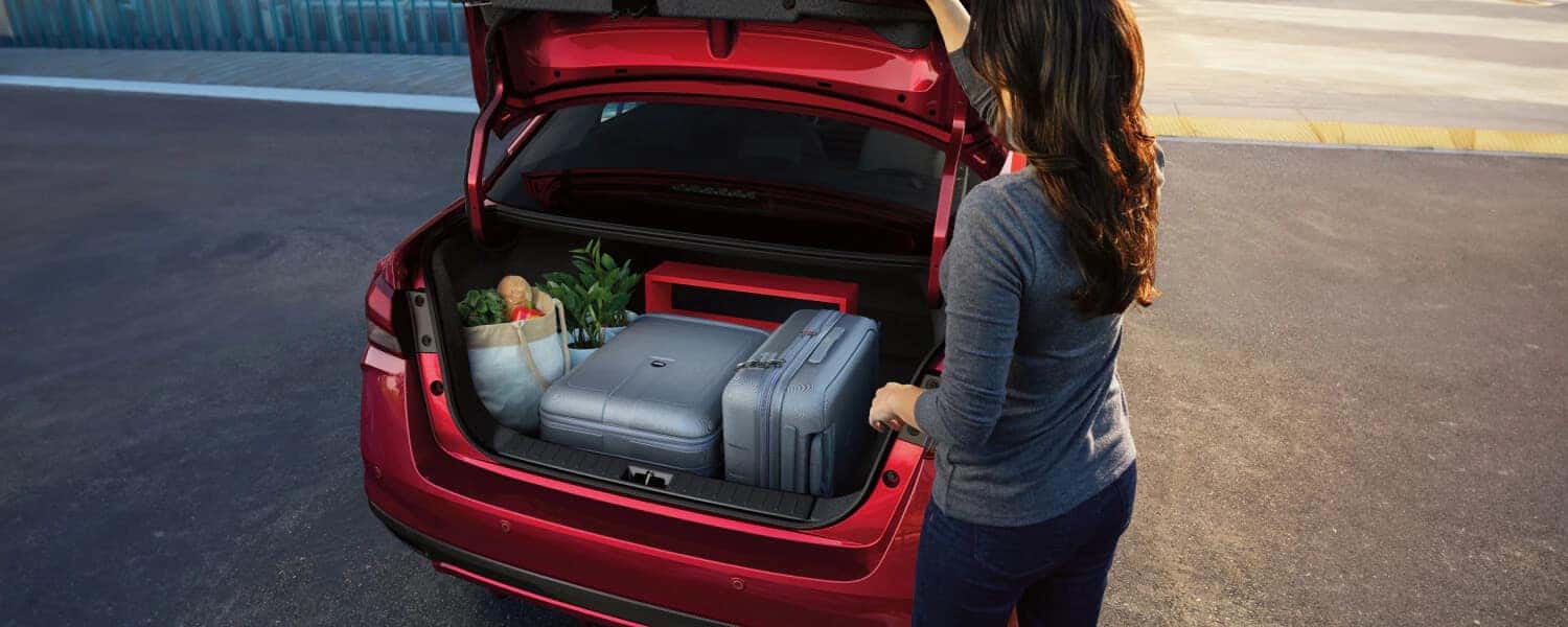 A woman loading the trunk of her 2025 Nissan Versa.