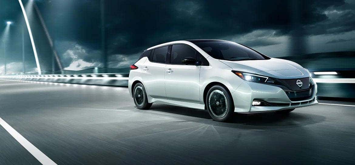 A 2025 Nissan Leaf driving on a storm bridge.