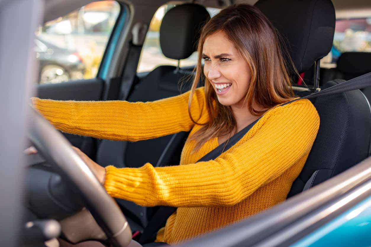 A woman tries to handle her car when it starts shaking.