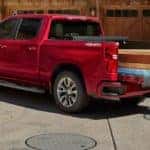 People removing wood beams from bed of red 2020 Chevy Silverado 1500
