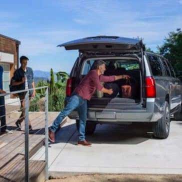 Man loading stuff into 2020 Chevrolet Suburban Cargo Area