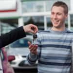 Couple receiving car keys by a dealer in a dealership