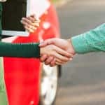 Business handshake to close the deal after buying a car, between a man and a woman