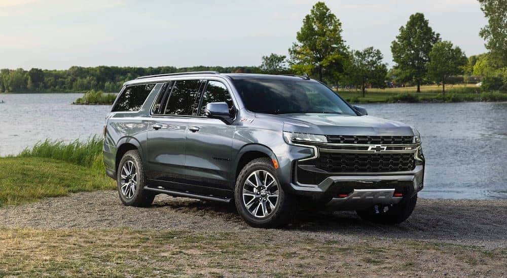 A silver 2021 Chevy Suburban parked in front of a lake after leaving a Guntersville Chevy dealer.