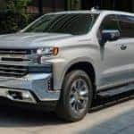 A silver 2021 Chevy Silverado 1500 is parked on a city street after leaving an Albertville Chevy dealer for information on the 2023 Silverado EV.