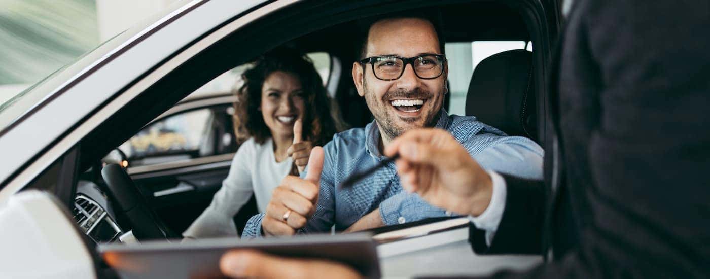 A couple is sitting in a car at an Albertville Chevy dealer.