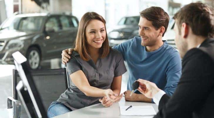 A couple is sitting inside a Huntsville Chevrolet dealer.