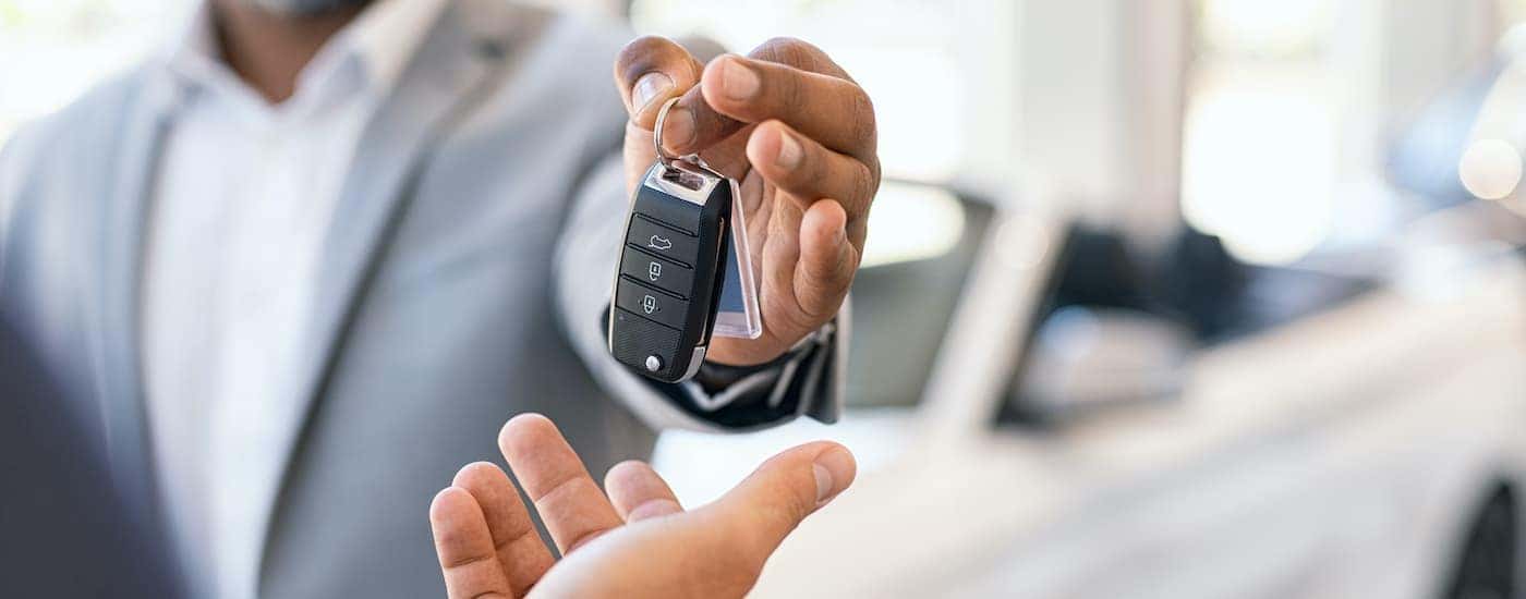 A salesman is shown passing a set of keys at a Huntsville Chevrolet dealer.