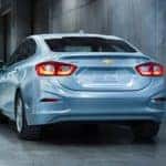 A white 2017 Chevy Cruze is shown from the rear driving through a tunnel after leaving a Guntersville used car lot.