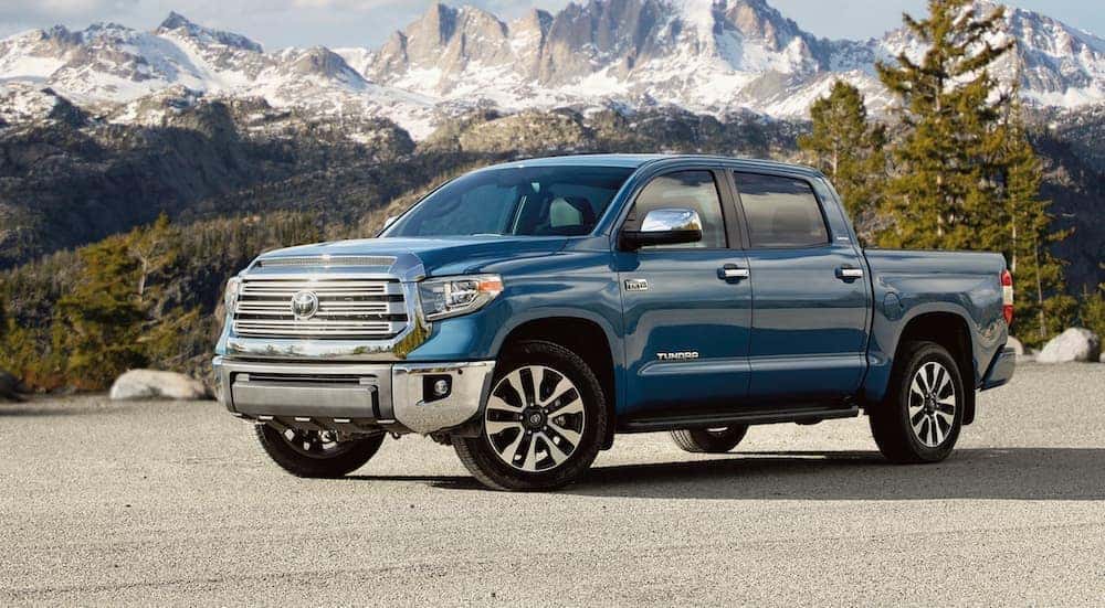 A blue 2020 Toyota Tundra parked in front of snowcapped mountains.