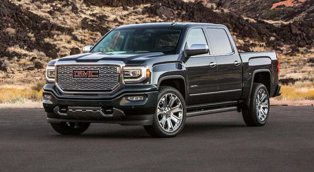 A black 2018 GMC Sierra 1500 parked in an empty lot at a used GMC dealer.
