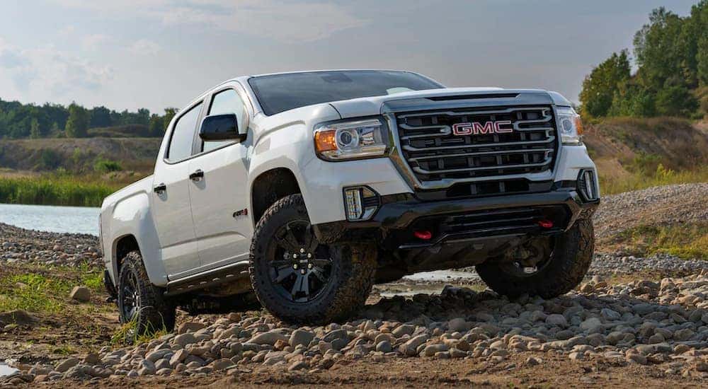 A white 2021 GMC Canyon AT4 off-roading on a rocky trail.