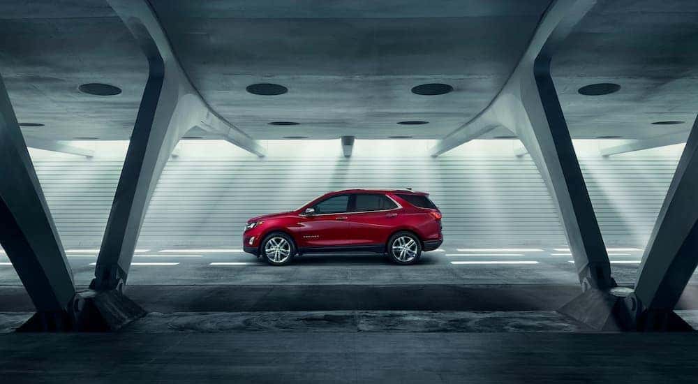 A red 2018 Chevy Equinox parked in a modern parking garage.