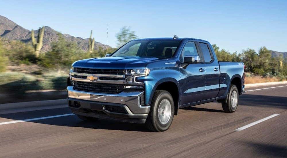A blue 2019 Chevy Silverado 1500 driving on a desert road.