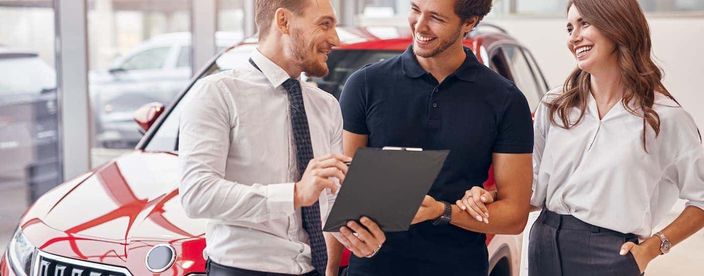 A couple is shown going over financing paperwork with a salesperson at an Arab Chevrolet dealership.