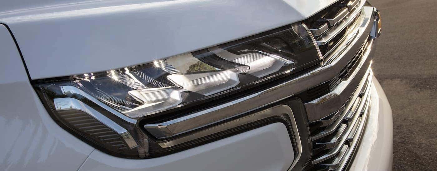 A close up shows the passenger side headlight on a white 2021 Chevy Suburban.