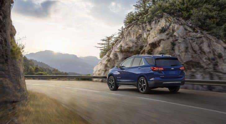 A blue 2022 Chevy Equinox Premier is shown from the rear at an angle.
