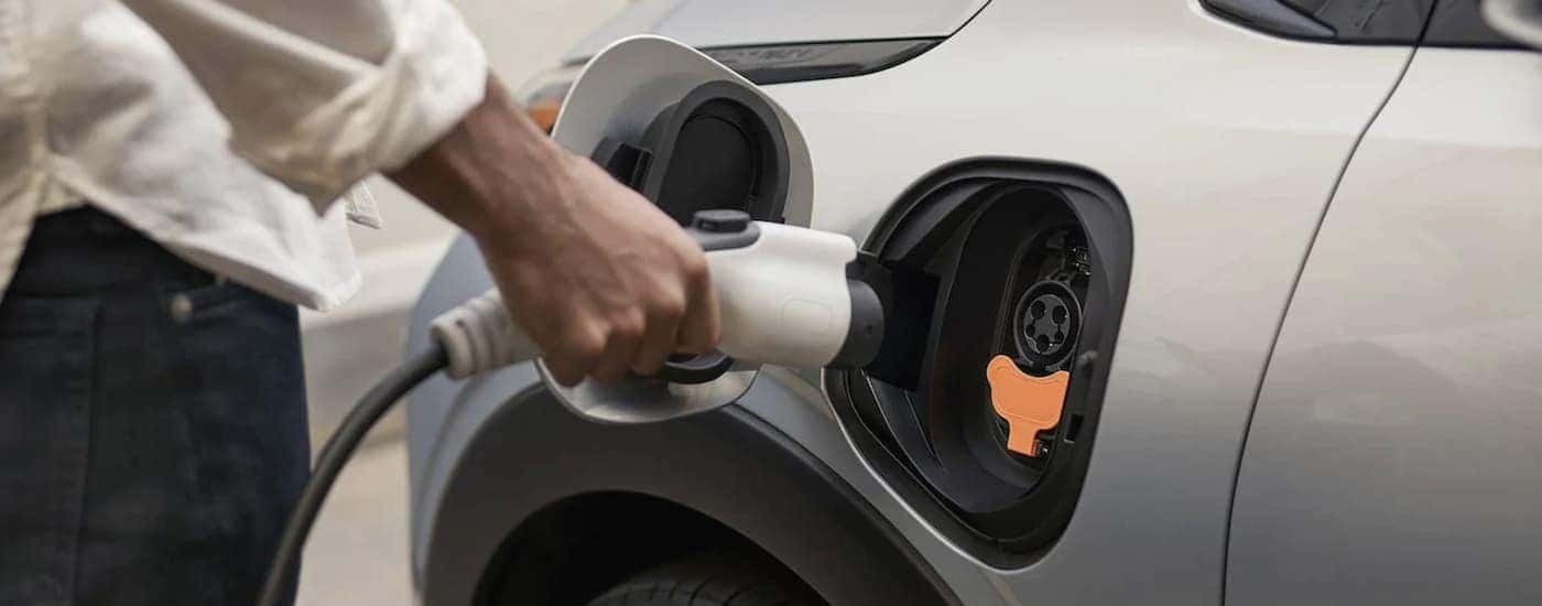 A close up shows a person plugging in a white 2022 Chevy Bolt EUV.