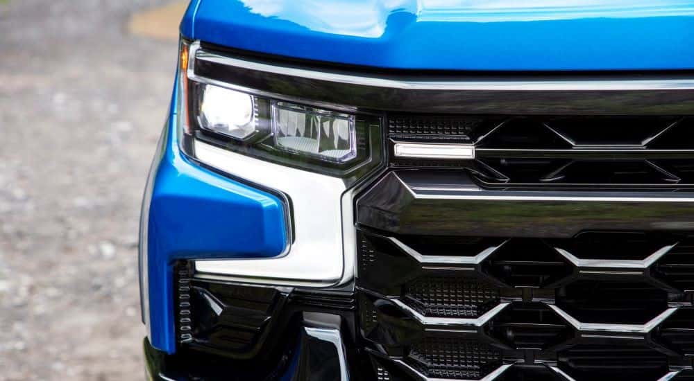 A close up of the passenger side headlight on a a blue 2023 Chevy Silverado ZR2.