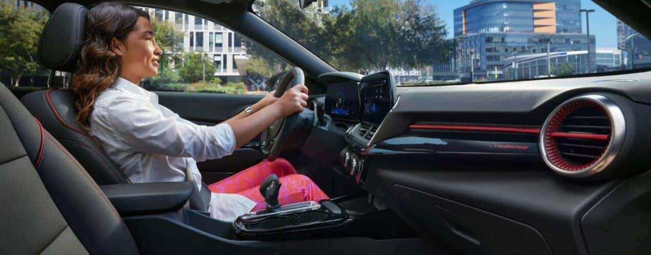 A person sis shown driving a 2024 Chevy Trax RS.