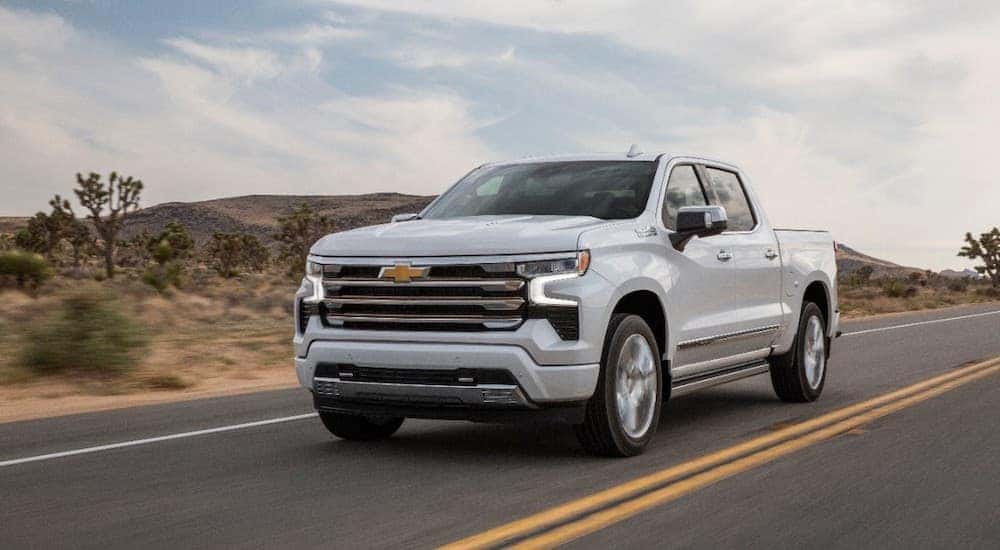 A white 2022 Silverado 1500 High Country driving through the desert