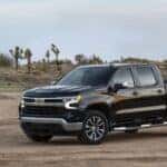 A black 2022 Chevy Silverado 1500 LT parked in the desert near joshua trees