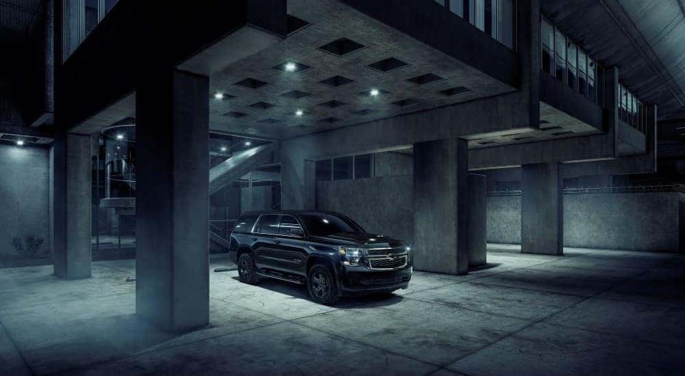 A black 2018 Chevy Tahoe Midnight parked in a concrete gallery with moody lighting