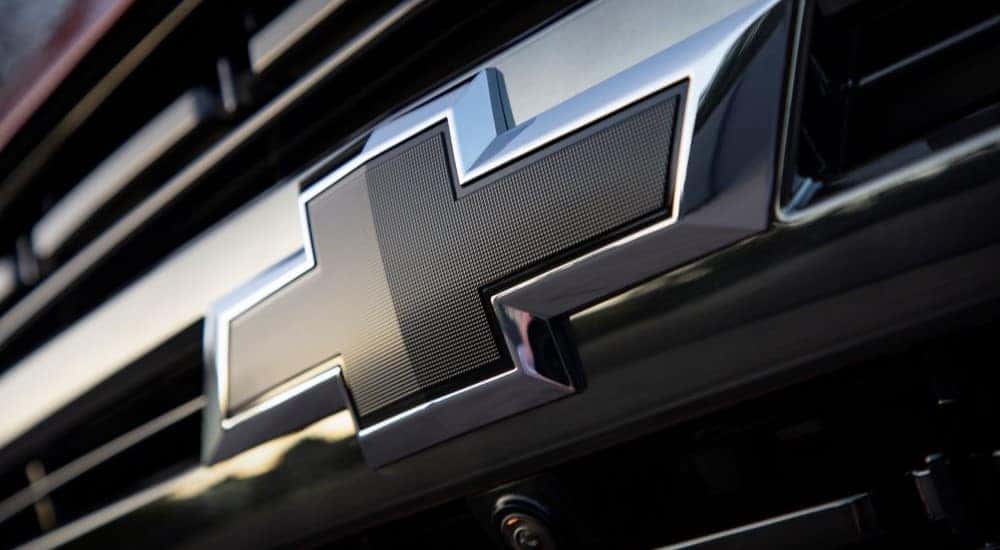 A close up of the Chevy badge on a red 2021 Chevy Tahoe RST.