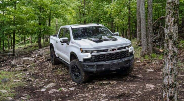 A white 2023 Chevy Silverado 1500 ZR2 Bison is shown from the front at an angle after leaving a Chevy Silverado dealership near Huntsville, AL.