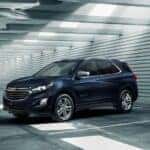 A blue 2021 Chevy Equinox is shown parked in a parking garage by a used Chevy dealer near Gadsen.