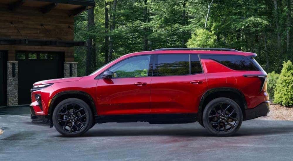 A red 2024 Chevy Traverse is shown parked on a driveway.