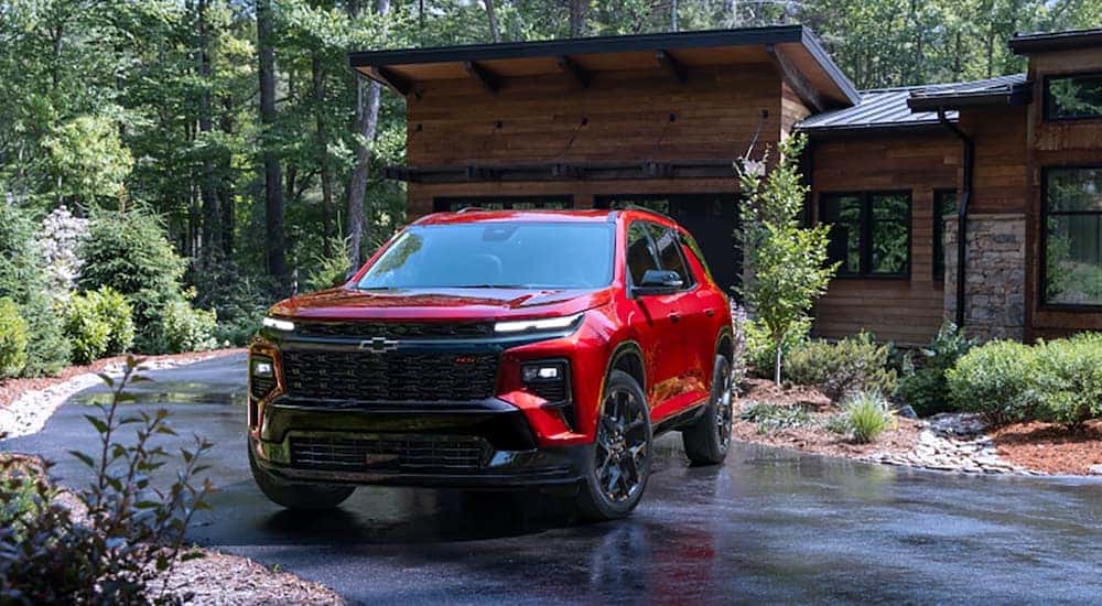 A red 2024 Chevy Traverse is shown parked in a driveway.