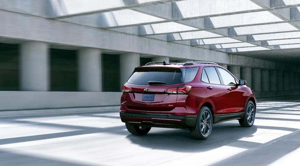 A red 2024 Chevy Equinox is shown driving in a tunnel.