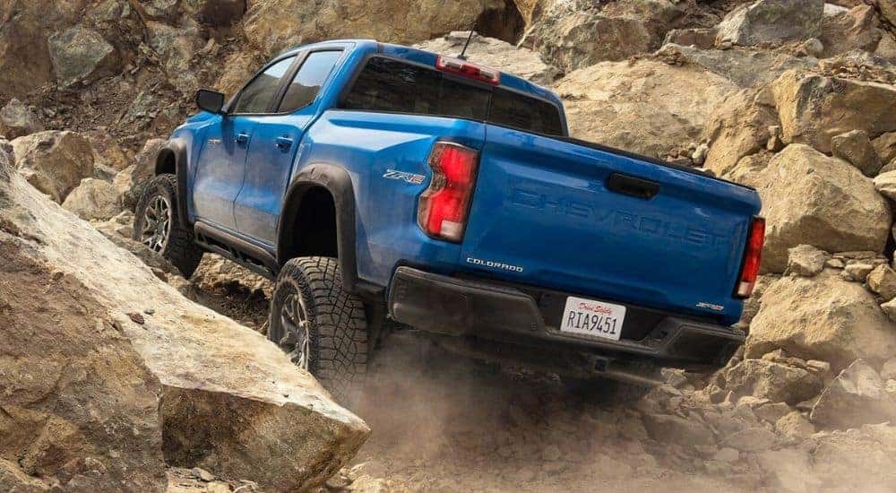A blue 2024 Chevy Colorado ZR2 is shown from the rear off-roading.