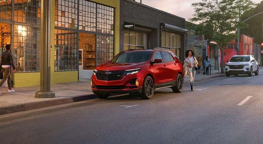 After a 2024 Chevy Equinox vs 2024 Mitsubishi Eclipse Cross comparison, a red 2024 Chevy Equinox RS, is shown parked near a store.