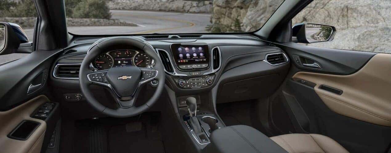The black interior of a 2024 Chevy Equinox is shown from the driver's seat.