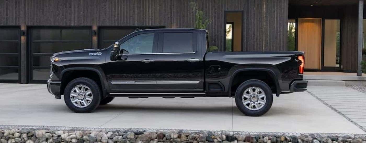 A black 2024 Chevy Silverado 3500HD High Country is shown parked on a driveway.