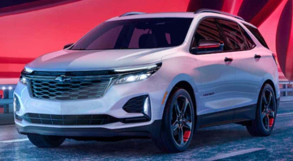 A white 2024 Chevy Equinox is shown driving on a bridge.