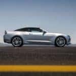 Silver 2016 Camaro Convertible driving on a road in front of mountains