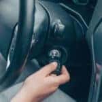 Hand turning a key in the ignition of a vehicle