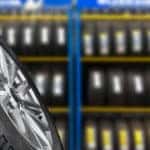 Close up of a tire in front of a shelf of tires in a tire shop