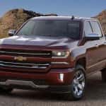 Red 2016 Chevy Silverado parked in front of dirt hills