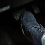 Man's foot, in a dress shoe, stepping on the brakes of a vehicle