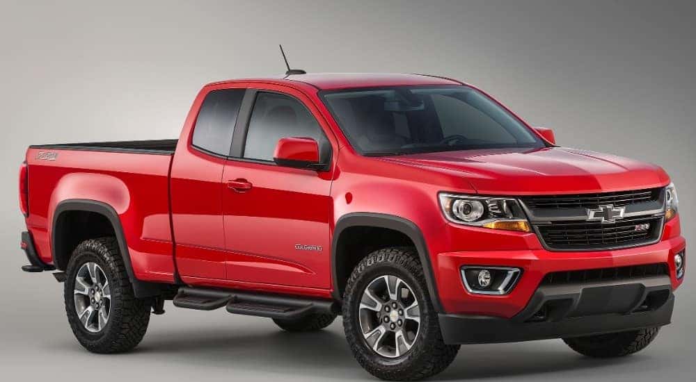 Red 2015 Chevrolet Colorado truck against a grey background
