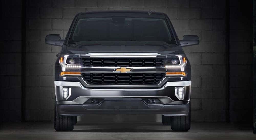 Front view of a black 2016 Chevrolet Silverado truck in a dark garage