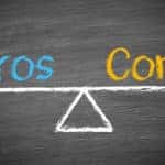 Chalkboard with a white scale drawn on it and the word "PROS" on one side, with "CONS" on the other