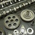 Various silver vehicle parts spread out on a grey surface