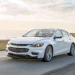 White 2016 Chevrolet Malibu driving down a paved road
